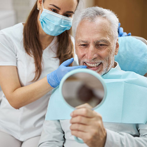 Dental implant patient checking new teeth