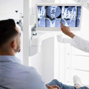 An Oral Surgeon reviews xrays with their patient